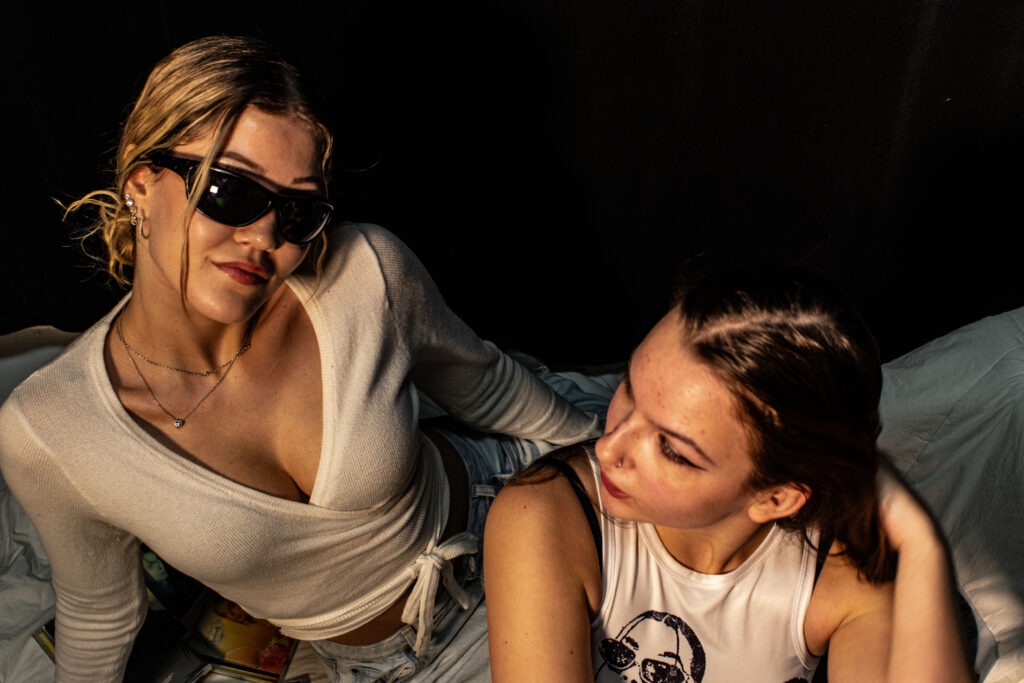 Deux femmes assise dont une qui regarde la caméra